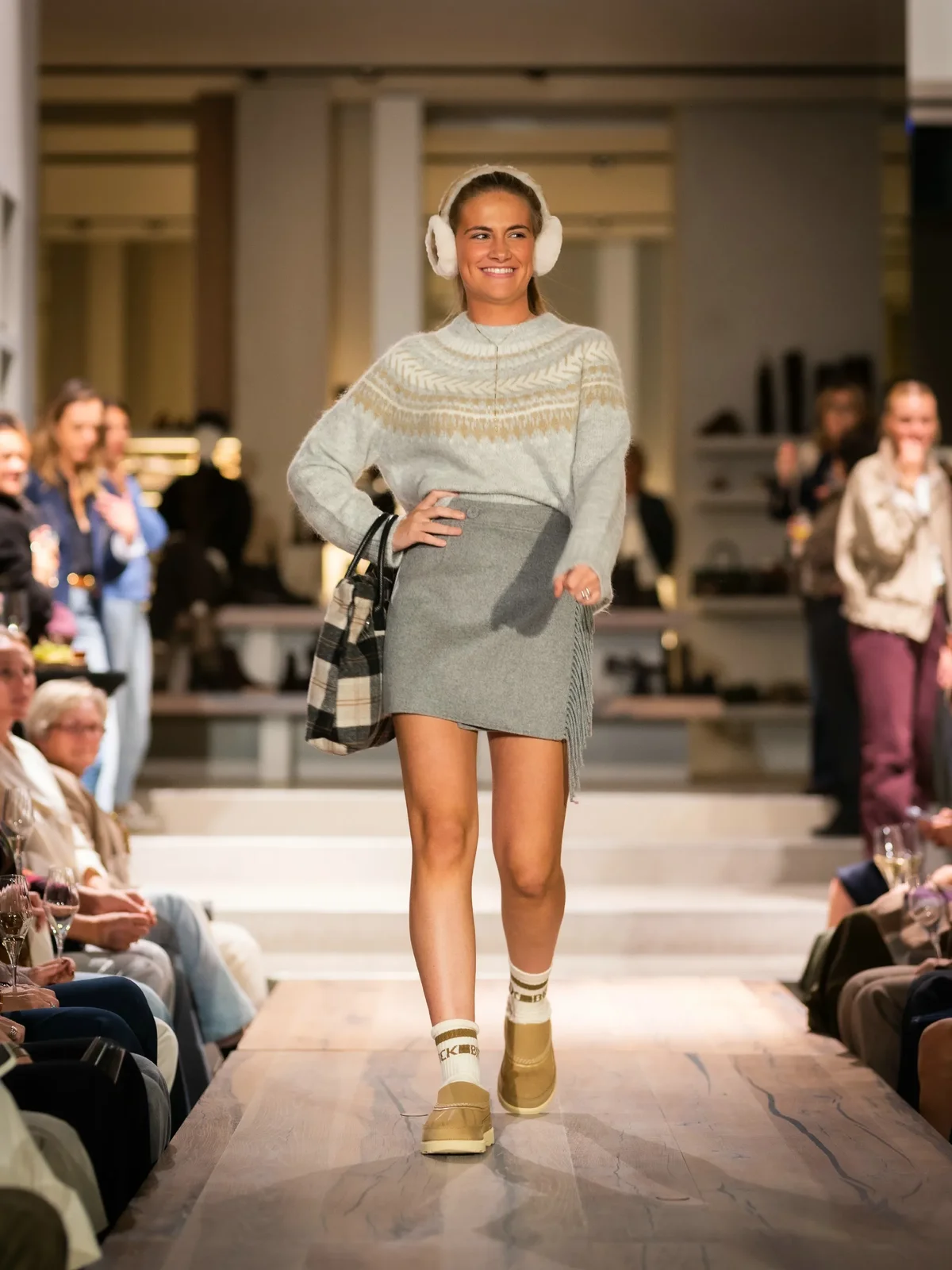 Grijze gebreide trui met korte rok, witte oorwarmers en beige boots