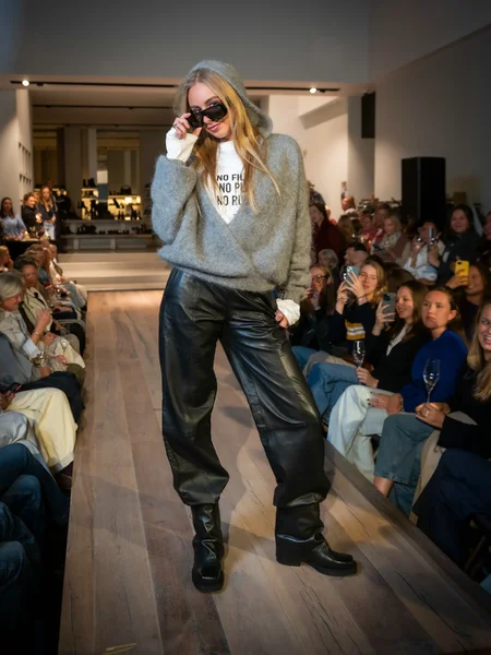 Grijze mohair wikkeltrui met hoodie en zwarte leren ballonbroek