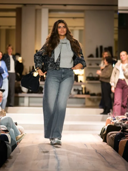 Blauwe jas met grijze top, broek en sneakers