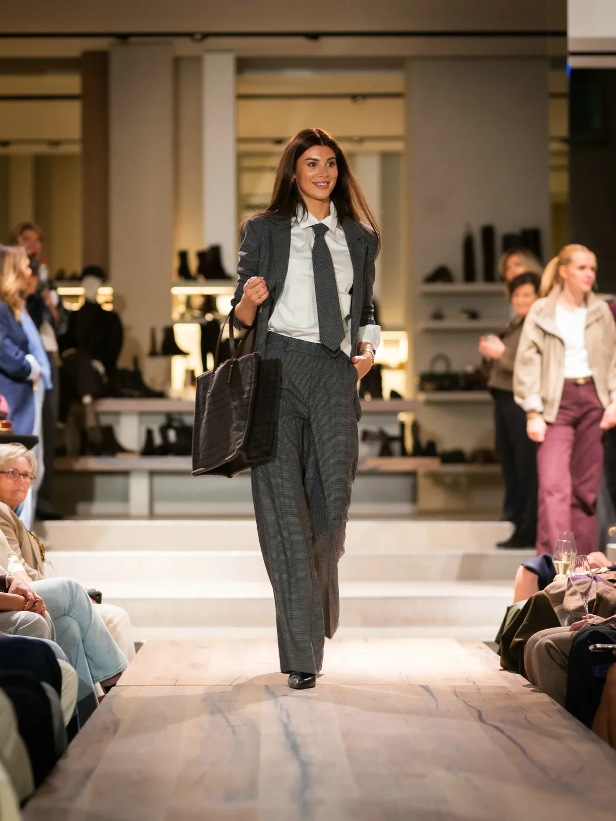 Grijze blazer met witte blouse, grijze broek en blauwe boots