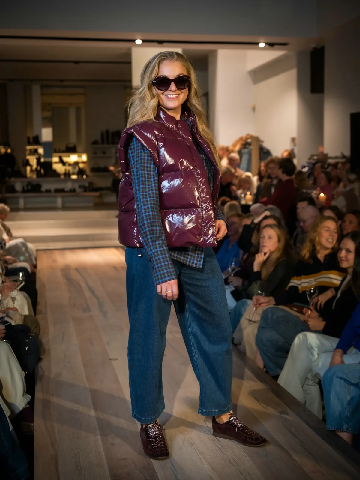 Paarse bodywarmer met blauwe blouse, jeans en bordeaux sneakers